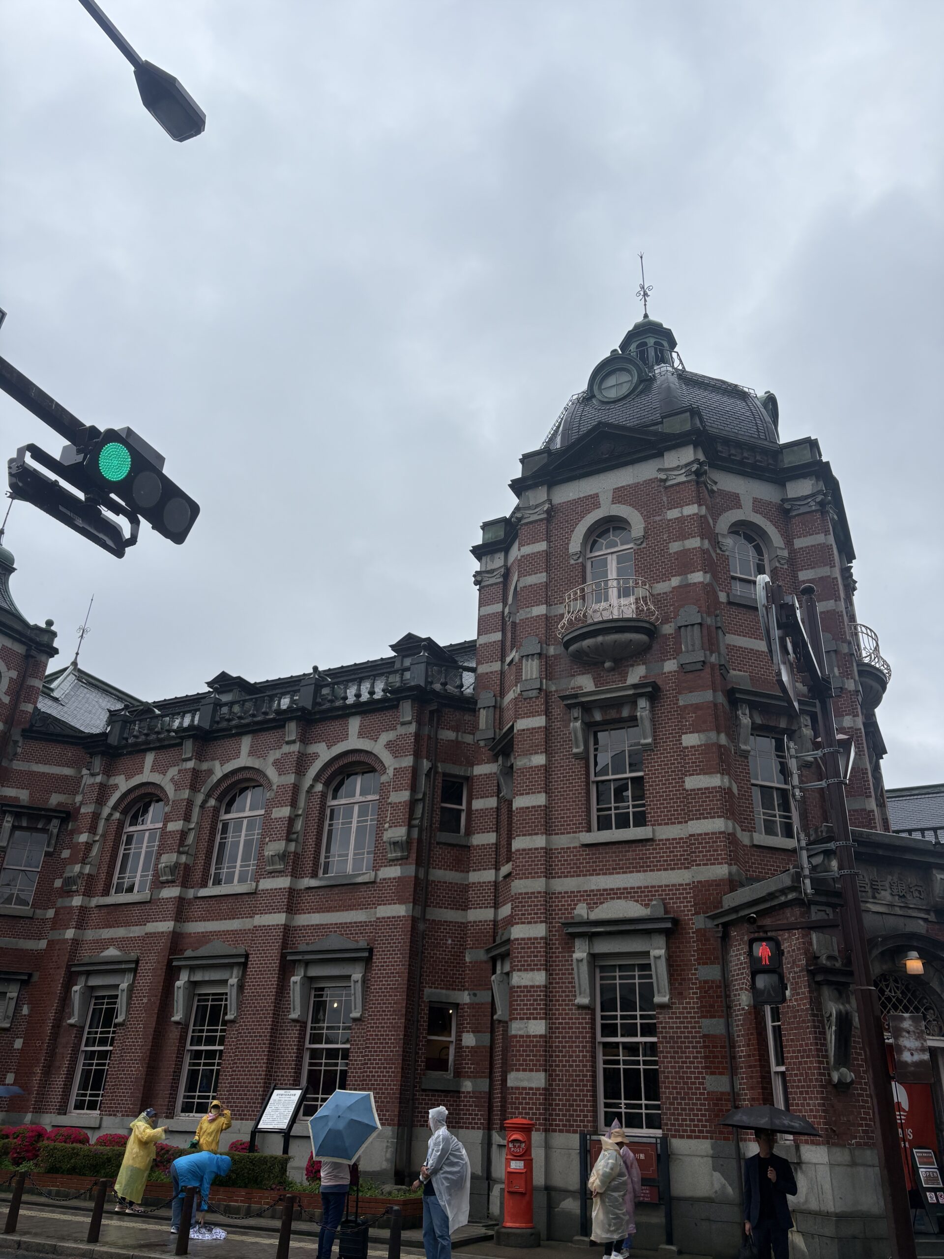 雨の中、傘を差し岩手銀行赤レンガ館